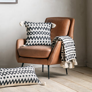 Aztec style cushions and throws on a modern leather armchair 